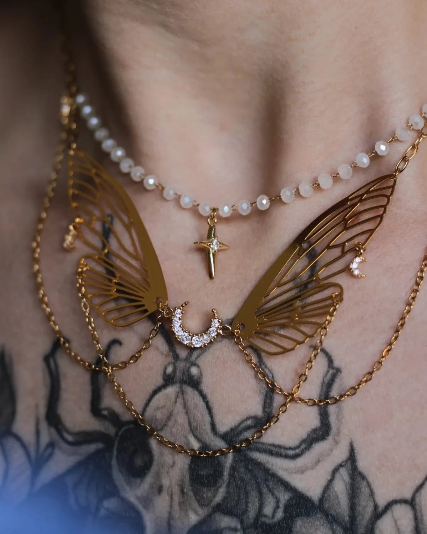 Collier doré L’Ange des Brumes - gros plan sur le cou, détails aile papillon et pendentif lune
