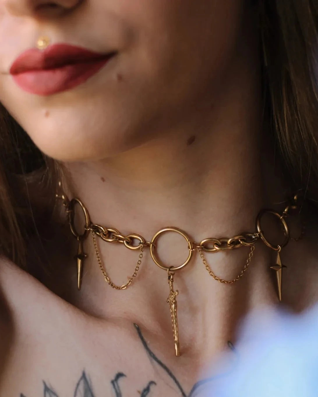 Collier Dague Astrale porté au cou, bijou doré avec anneaux et dagues symboliques, style mystique