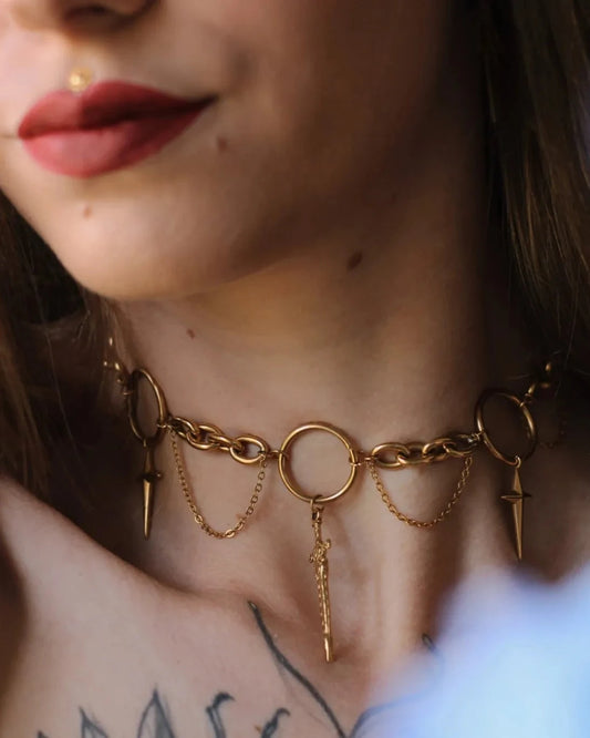 Collier Dague Astrale porté au cou, bijou doré avec anneaux et dagues symboliques, style mystique