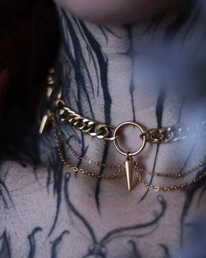 Collier Antarès en acier inoxydable doré avec maillons épais, chaînes drapées et pendentifs pointes.