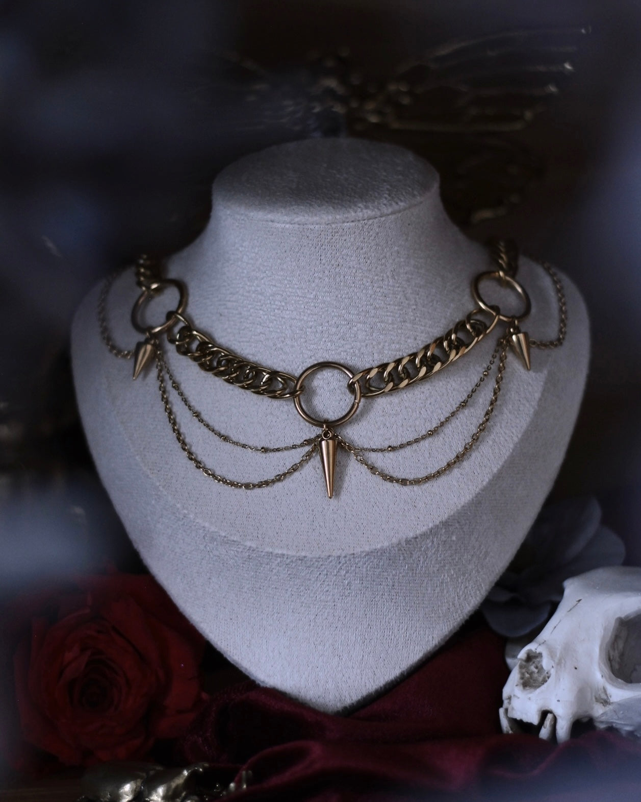 Collier Antarès en acier inoxydable doré avec maillons épais, chaînes drapées et pendentifs pointes.