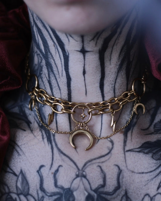Collier Astéria doré avec étoile centrale ornée d’un cristal et chaînes suspendues