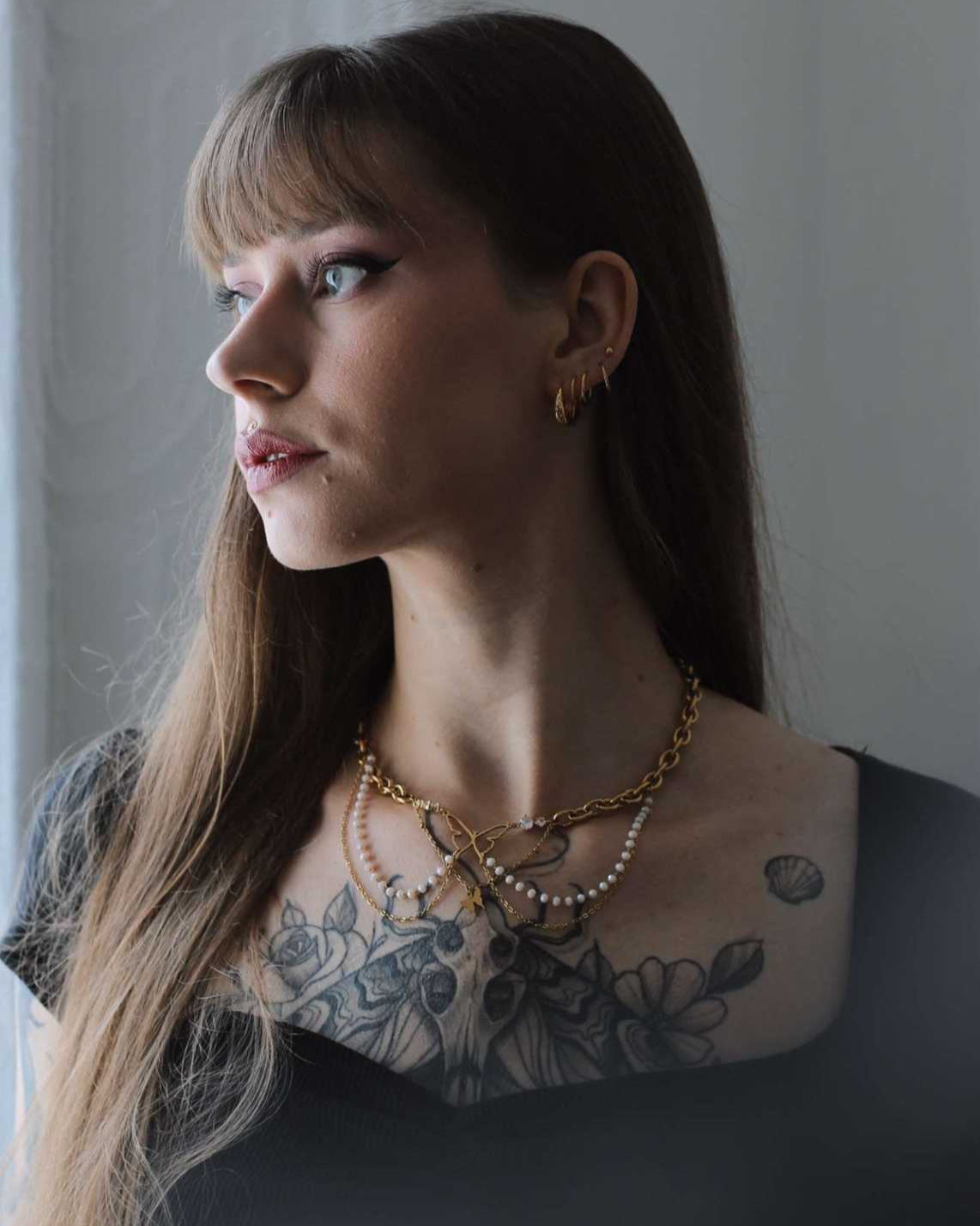 Femme portant le collier Battement Sacré - collier papillon doré et perles Vénys, bijou poétique