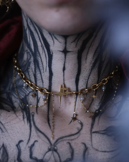 Collier Comète doré avec étoile centrale, chaînes suspendues et breloques étoilées