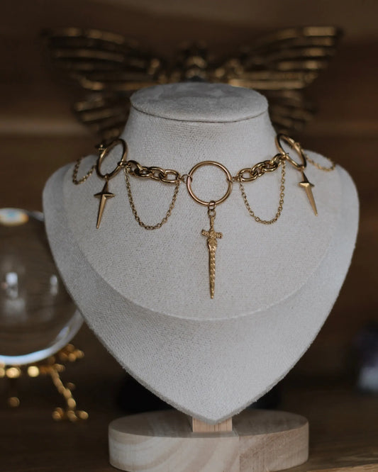 Collier doré Dague Astrale présenté sur buste, avec pendentifs en forme de dagues et chaînes fines