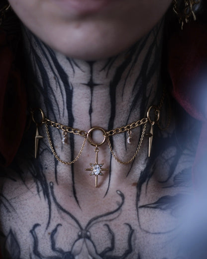 Collier Nébuleuse doré avec étoiles, lunes suspendues et pendentif central orné d’un cristal