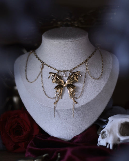 Collier Psyché doré avec pendentif papillon, chaînes suspendues et zircons scintillants.