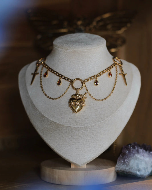 Collier Saignée d’Ambre sur présentoir - bijou doré avec croix, chaînes et pierres d’ambre