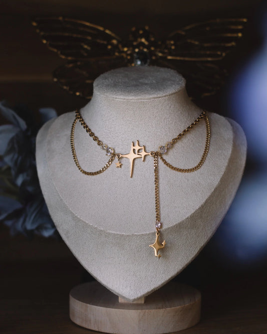 Collier doré Nuit Filante exposé sur buste, bijou céleste étoilé avec pendentif comète et cristaux.